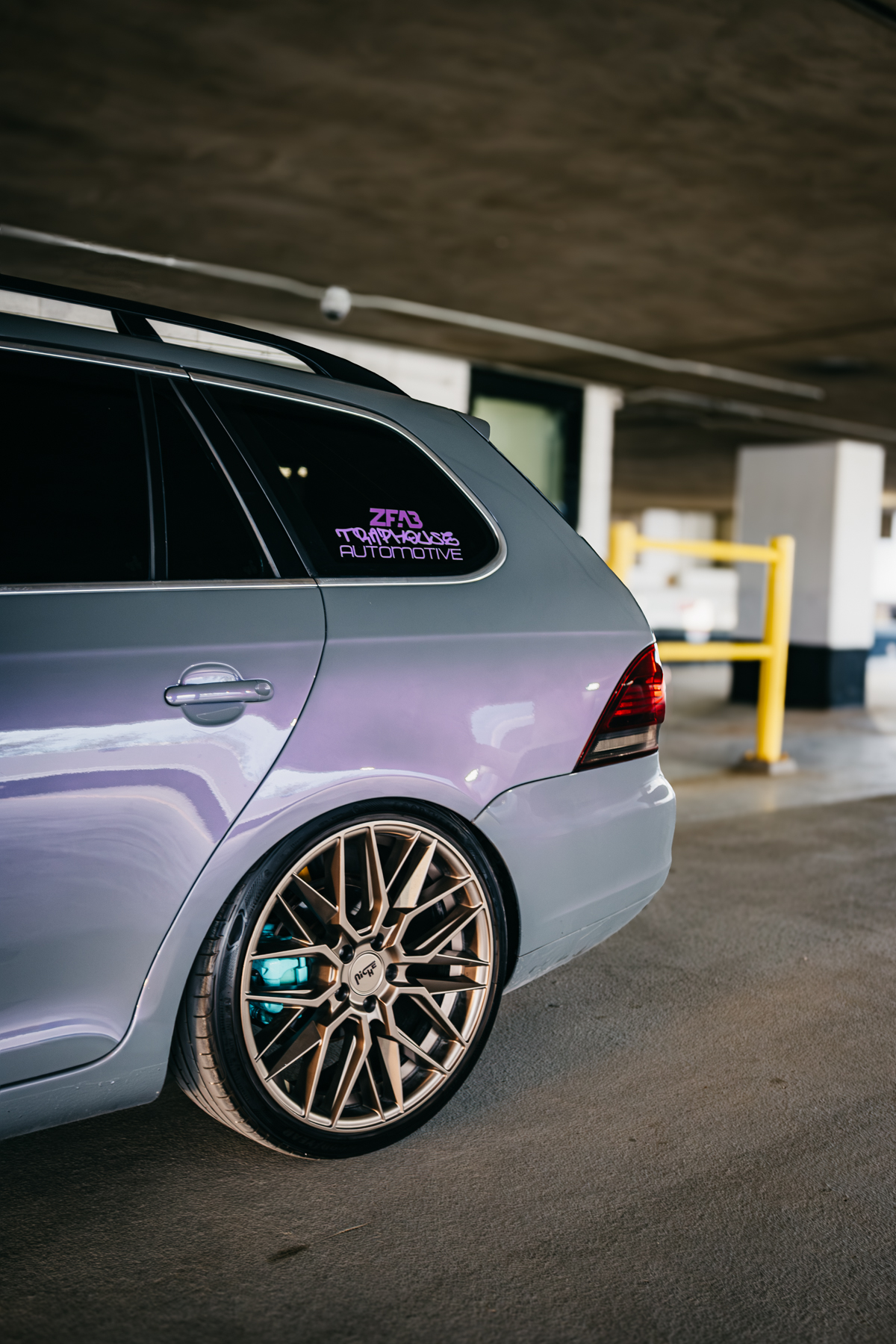 The back end of a repainted VW Golf Car. The car is grey with a pearlescent overlay, with aftermarket tires.