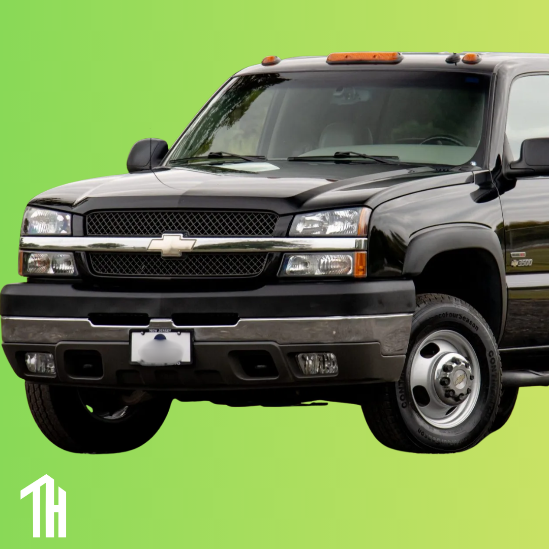 The front half of a black 2003 Chevrolet Silverado 2500 is on a lime green background. In the bottom left corner, the Traphouse Automotive logo is seen in white.